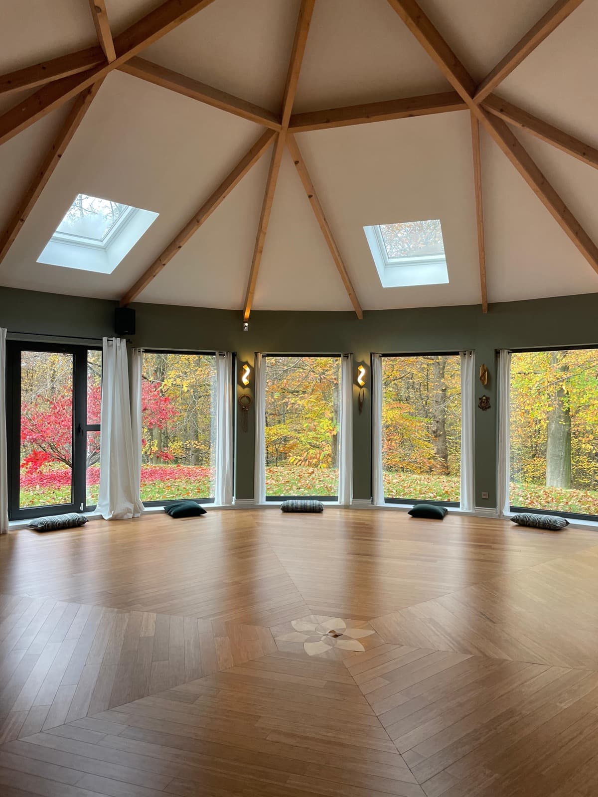 La salle de l'atelier, baies vitrées ouvertes sur la forêt d'automne